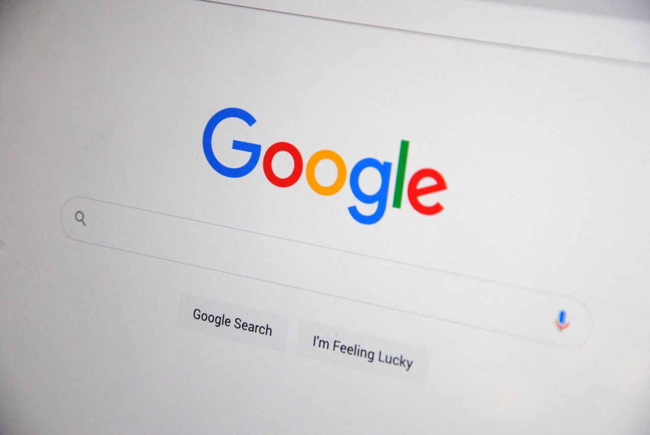 hero-img-01 Close-up of the Google homepage on a screen showing search options.