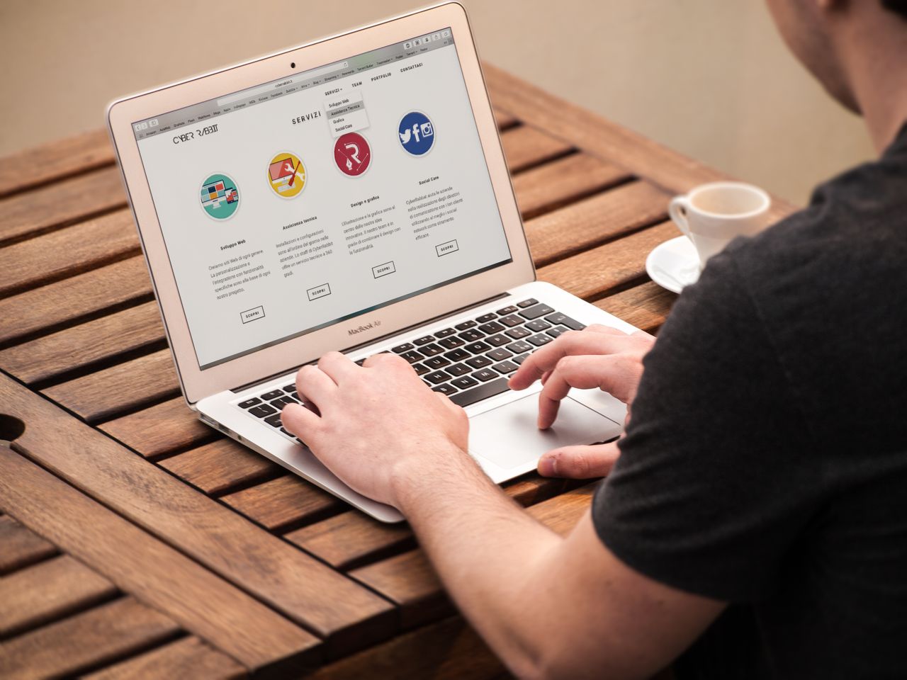 Crafting Captivating Headlines: Your awesome post title goes here Person typing on laptop outdoors, illustrating remote work lifestyle with coffee at a wooden table.