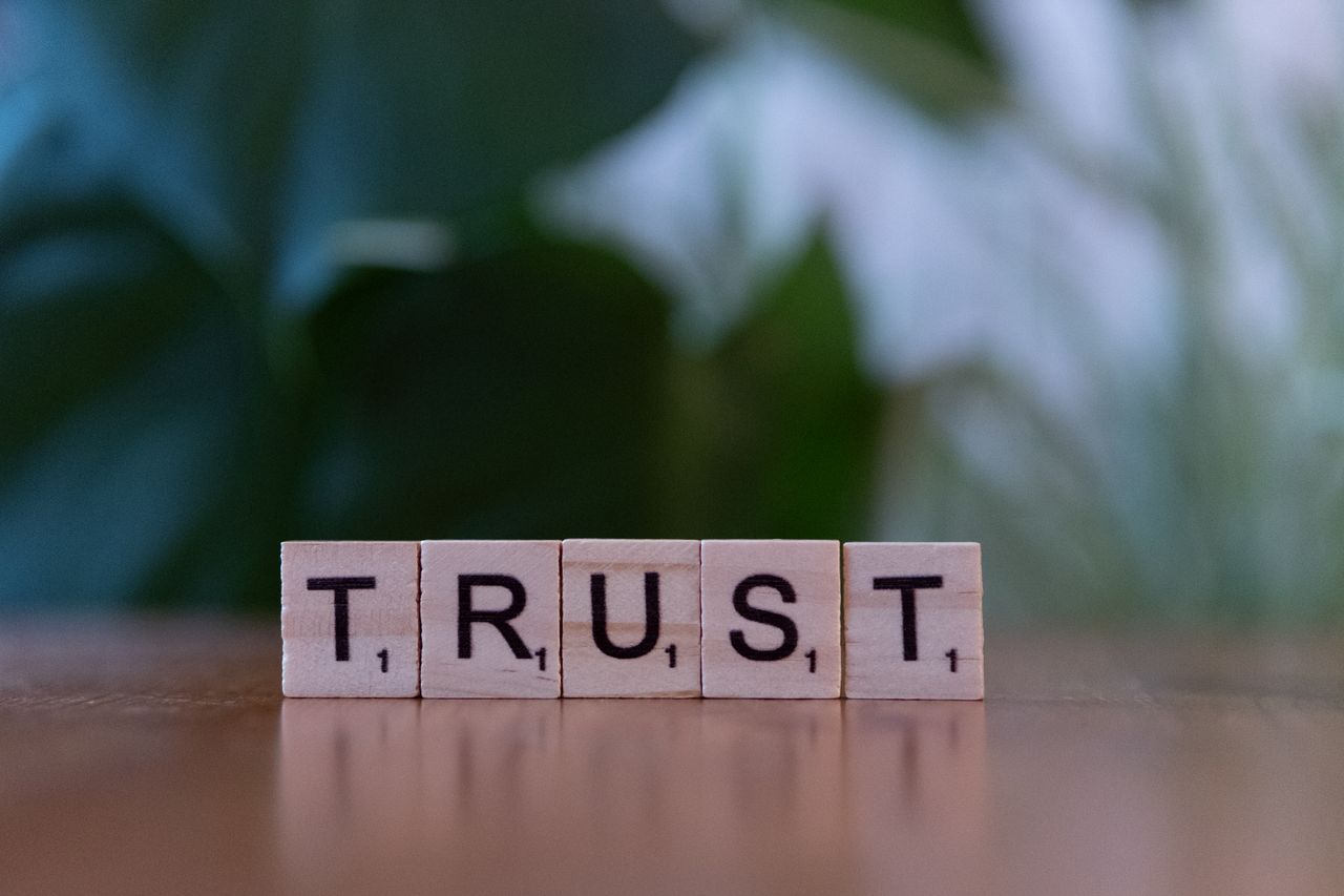 gallery-4 Wooden letter tiles spelling TRUST on a wooden surface, symbolizing integrity and values.
