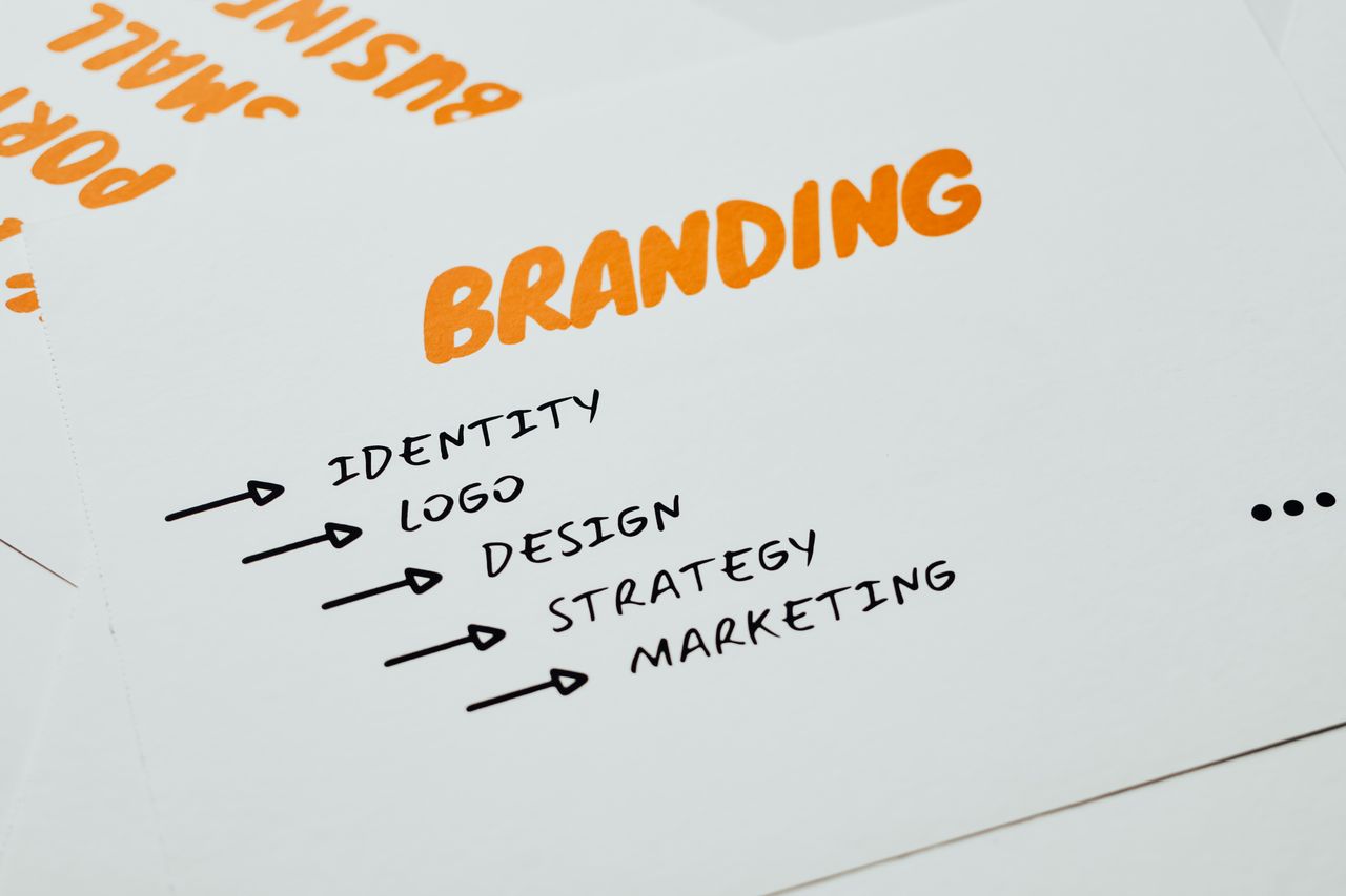 gallery-2 Close-up of a paper with branding, identity, design, strategy, and marketing concepts in orange and black.
